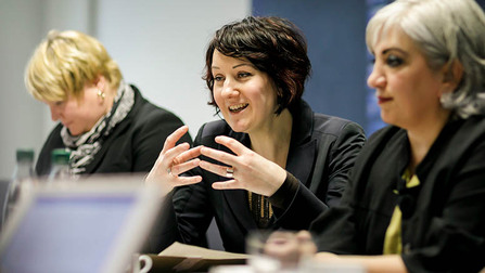 Drei Frauen mit kurzen Haaren sitzen nebeneinander, die Frau in der Mitte spricht lächelnd (Bild anzeigen)