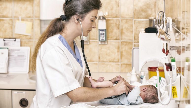 Jasmina Abdulović hört mit einem Stethoskop ein Baby ab.