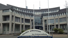 Auf einem Schild vor dem grauen Gebäude des Jobcenters steht "Herzlich Willkommen"Öffnet Seite: Jobcenter-Porträt Hochsauerlandkreis
