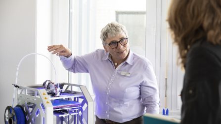 Barbara Wenders-Scholl trägt Brille und kurze graue Haare und steht neben 3D-Drucker.Öffnet Seite: Klicken statt warten