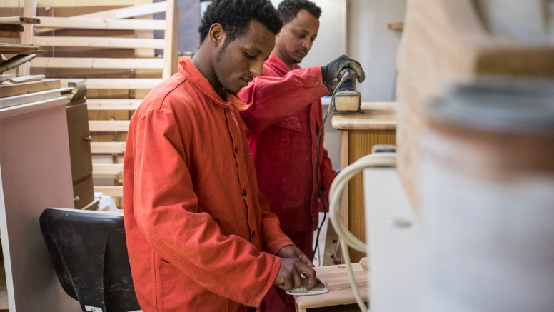 Zwei somalische Geflüchtete bei der Arbeit in der Holzwerkstatt