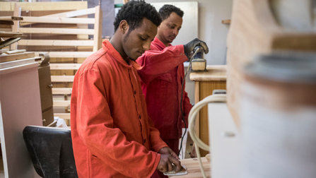 Zwei somalische Geflüchtete bei der Arbeit in der Holzwerkstatt (ausgwähltes Bild)