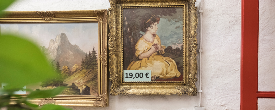 Ein Bild von einer Malerei, das ein Kind in gelbem Kleid zeigt. Ein Preisschild mit 19,00€ ist in den gold-verzierten Rahmen gesteckt.