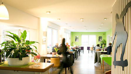 Innenansicht des Café Nordbahntrasse, ein heller Raum mit grünen Akzenten (Bild anzeigen)