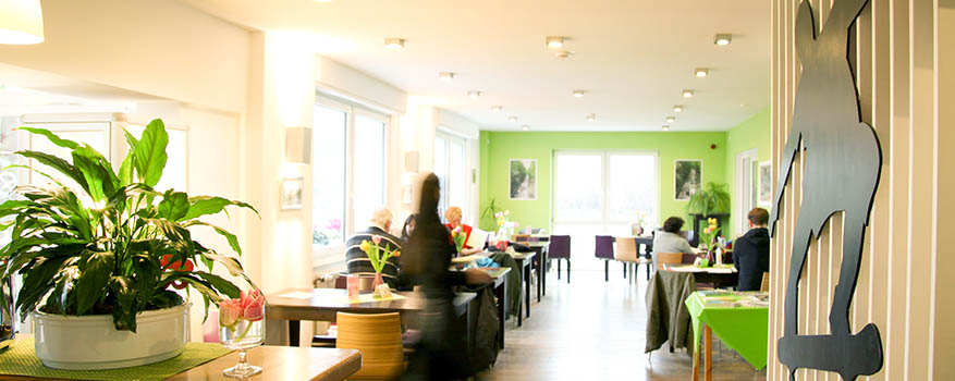 Innenansicht des Café Nordbahntrasse, ein heller Raum mit grünen Akzenten
