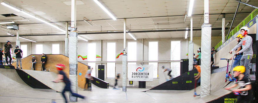 Kinder skaten auf Rampen in der Skatehalle Wicked Woods