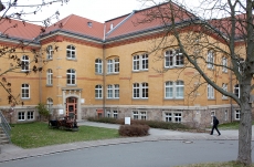 Außenaufnahme des Jobcenters Zwickau. Das Gebäude ist gelb-orange mit rotem Dach. 