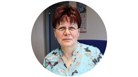 Porträtfoto von Frau Steinert. Sie hat kurze rote Haare und trägt eine Brille sowie eine Bluse mit Schmetterlingsmuster.Öffnet Seite: 3 Fragen an Sabine Steinert