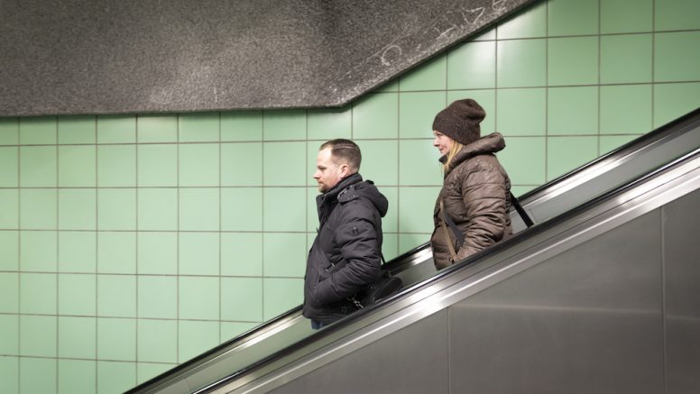 Christian Kürpick und Jenny Vesper auf der Rolltreppe eines U-Bahnhofs