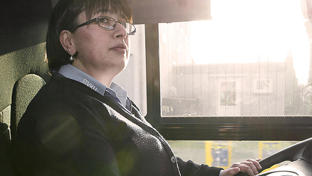 Fatma Akgün sitzt am Steuer eines Linienbusses. Sie hat kurze schwarze Haare und trägt eine längliche Brille.  (ausgwähltes Bild)