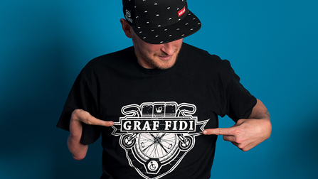Portrait von Graf Fidi, er trägt ein T-Shirt mit seinem Namen darauf gedruckt.Öffnet Seite: Rappen für mehr Inklusion