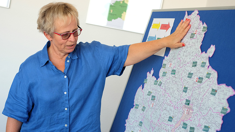 Christiane David zeigt auf eine Landkarte des Landkreises.