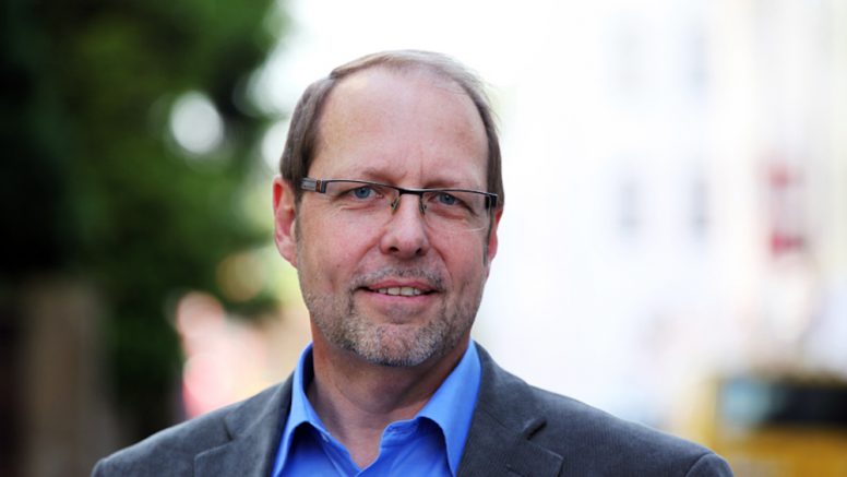 Porträtfoto Uwe Kastien. Er hat kurze graue Haare und trägt eine Brille.