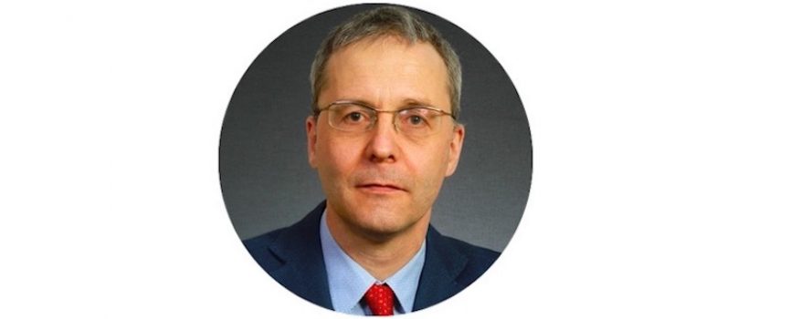 Porträtfoto von Prof. Dr. Martin Brussig. Er hat kurze Haare und trägt eine Brille, ein dunkelblaues Sakko, ein hellblaues Hemd und eine rote Krawatte.